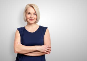 mittelalte-blonde-frau-mit-verschraenkten-armen